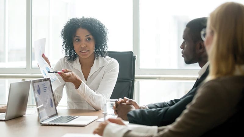 translate-print-coworkers-discussing-printed-chart-it Collaboratori che discutono del documento stampato