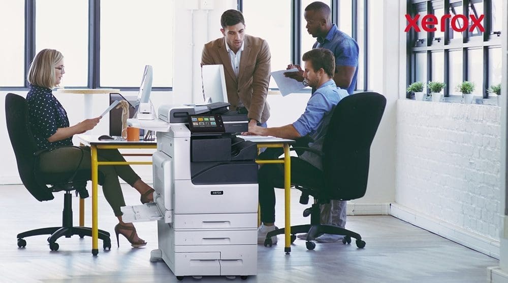 Impiegati che collaborano vicino a una stampante Xerox.