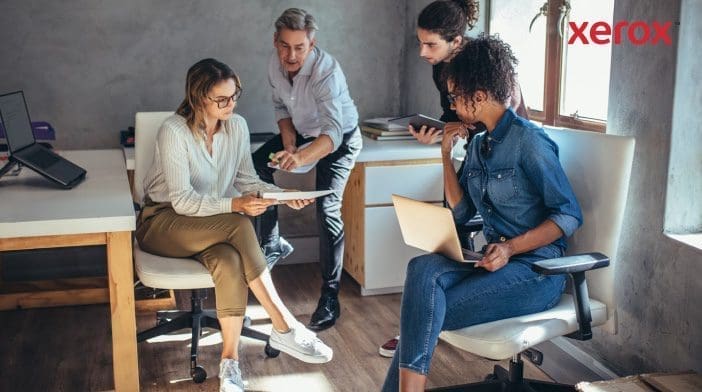 Quattro colleghi che collaborano in un ufficio moderno.